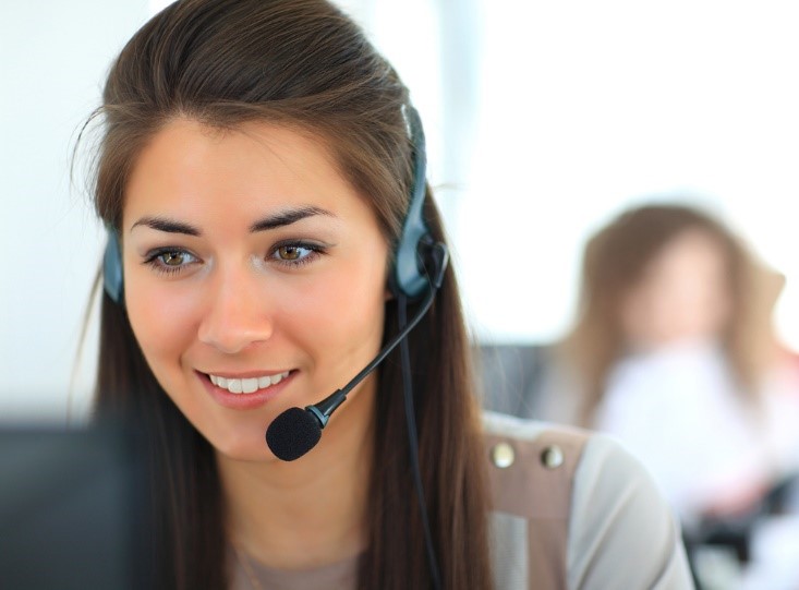 A woman with headphones on smiling for the camera.